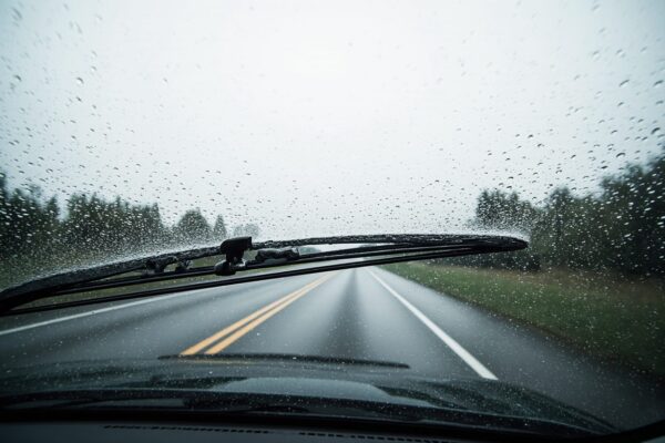 Close-up view from inside a car demonstrating dangerous visibility loss caused by streaking from worn wiper blades, emphasizing the need for early inspection.