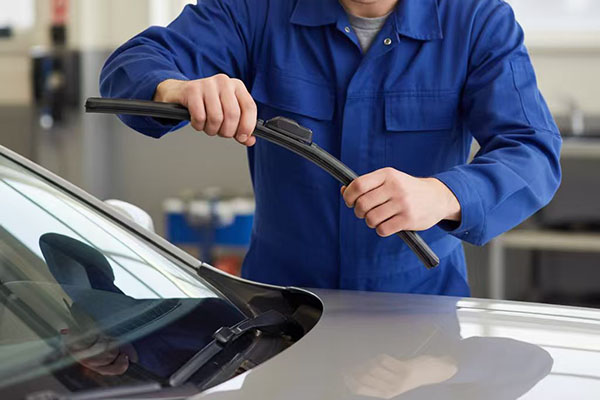 Encourages proactive maintenance by showing a driver replacing wipers ahead of bad weather for safety.
