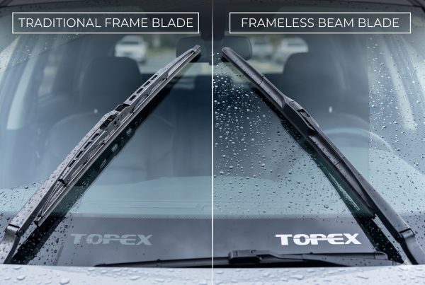 Side-by-side view of traditional frame and modern frameless wiper blades installed on a car windshield