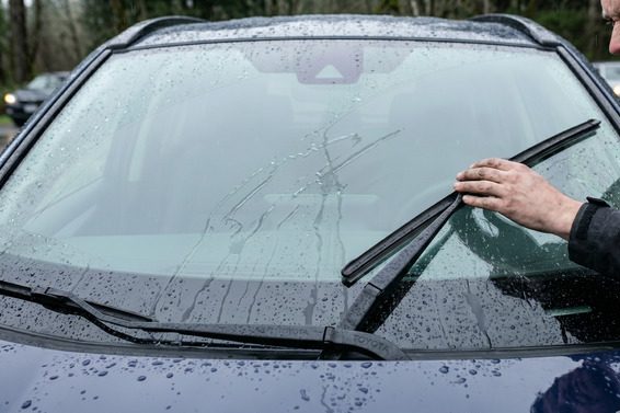 Frameless wiper blade failing to fit properly on a curved windshield, showing installation problem